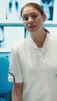 Vertical Doctor starting a meeting in a treatment center to discuss future care plans, analyzing test results with the staff to improve health services. Medical records for disease prevention. Camera A. video