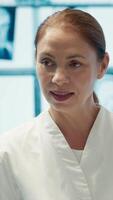 Vertical Specialist leading a department meeting with medical team to discuss treatment service, analyzing test results with staff to improve collective work. Using health care records for help. Camera A. video