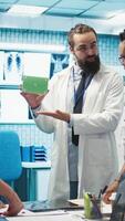 Vertical Medical expert showing a box with green screen during a meeting for diagnosis and disease prevention, conducting a detailed evaluation of x ray scans and lab test results in a clinic. Camera B. video