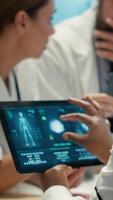 Vertical Radiologists diverse team reviewing x rays to discuss patient care in a facility. Team of skilled healthcare specialists working together to provide accurate diagnosis and treatment plans. Camera A. video