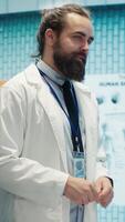 Vertical Hospital team examine x rays and discusses treatment strategy in a medical cabinet. Physicians with expertise in radiology and disease prevention doing collective work for health service. Camera A. video