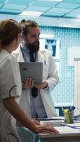 Vertical Neuroscience expert reviewing mri brain scan results with doctors, discussing the right treatment plan for disease prevention. Licensed neurologist and his staff examine tomography. Camera B. video