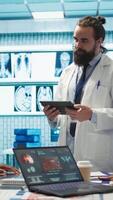 Vertical Neurology specialist examines magnetic resonance imaging brain scan with team during a meeting, looking at tomography for accurate neuroscience diagnosis. Diverse team of doctors. Camera B. video