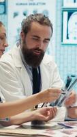 Vertical Healthcare experts in a meeting discussing treatment protocols and improvements. Doctors and nurses evaluating diagnostic results in a private clinic to enhance medical services quality. Camera A. video