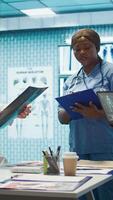 Vertical Medical professionals review x ray results and discuss patient care strategies during a meeting. Team of licensed healthcare experts working to provide accurate diagnosis in a clinic. Camera B. video