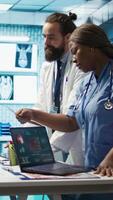 Vertical Radiologists team analyze x rays and discuss treatment options in a medical office. Team of licensed healthcare experts working together to provide diagnostic, radiology expertise. Camera B. video