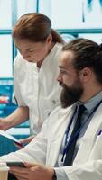 Vertical Healthcare experts in a treatment center analyzing x ray scans and test results in a meeting, collaborating on diagnostics and treatment plans for disease prevention. Collective work. Camera A. video