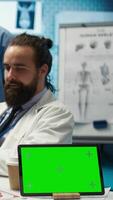 Vertical Diverse team of medics analyze x rays next to mockup copy space and discuss treatment plans in a medical office. Healthcare specialists working to provide diagnosis on insurance. Camera B. video