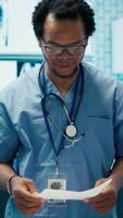 Vertical Expert assistant discussing hospital records with specialists team in a meeting, medical staff evaluating a new treatment plan. Medics at a private clinic analyzing exam test results. Camera A. video