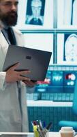 Vertical Skilled team of medics examine x ray scans and discuss health care plans during a research meeting. Diverse healthcare staff working to provide accurate diagnostics in a private clinic. Camera A. video