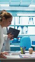 Vertical Skilled team of medics examine x ray scans and discuss health care plans during a research meeting. Diverse healthcare staff working to provide accurate diagnostics in a private clinic. Camera B. video