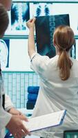 Vertical Radiologists and specialists examine x ray test results for treatment plans. Group of licensed healthcare experts working in a private clinic to provide medical services on insurance. Camera A. video