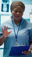 Vertical Medical team reviewing diagnostic x rays in a healthcare facility, focusing on disease prevention and early virus detection to provide treatment care. Licensed doctors consulting results. Camera A. video
