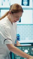Vertical Team of doctors review electrocardiogram test results at a private facility, analyzing human organs on a radiography for disease prevention. Consulting hospital records and cardiology scan. Camera A. video