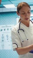 Vertical Specialists discuss x ray results and patient care strategy in a medical office. Team of licensed doctors working together to provide accurate diagnosis and effective treatment plans. Camera B. video