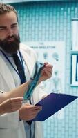 Vertical Doctors and radiologists review human anatomy scans to develop treatment service. Doing teamwork and expertise in radiology and diagnostics for correct healthcare solutions. Camera A. video