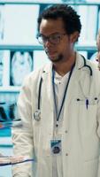 Vertical Group of healthcare workers analyzing diagnostic data and planning treatment in a private clinic, emphasizing collaboration. Coordinating recovery plans after recent test results. Camera A. video