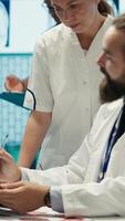 Vertical Experts team examine test results scans to develop treatment service, discussing potential diagnosis and insurance. Professional medics working together to provide medical assistance. Camera A. video