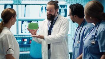 Medic presenting a box with isolated mockup screen during a meeting for disease prevention, conducting analytics and control of x ray scans results in a facility. Radiology department. Camera A. video
