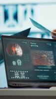 Vertical Radiologists team analyze x rays and discuss treatment options in a medical office. Team of licensed healthcare experts working together to provide diagnostic, radiology expertise. Camera A. video