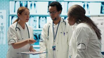 Group of healthcare workers analyzing diagnostic data and planning treatment in a private clinic, emphasizing collaboration. Coordinating recovery plans after recent test results. Camera A. video