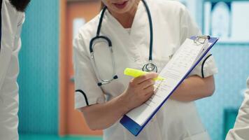 Team of medical experts highlighting x ray test results on healthcare records before providing treatment for a disease, collective work with expertise. Doctors ensuring fast recovery. Camera A. video