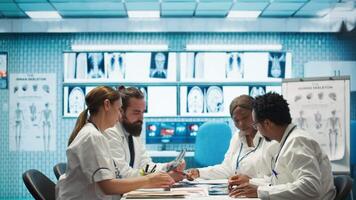 Radiologists and doctors analyze x rays and discuss patient care in a medical office. Team of healthcare specialists working together to provide accurate diagnosis and treatment plans. Camera B. video