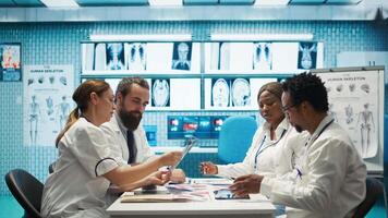Healthcare experts in a meeting discussing treatment protocols and improvements. Doctors and nurses evaluating diagnostic results in a private clinic to enhance medical services quality. Camera B. video