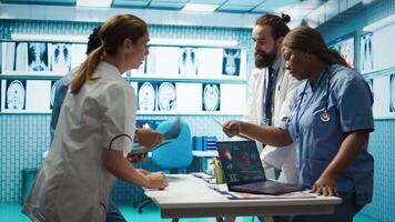 Radiologists team analyze x rays and discuss treatment options in a medical office. Team of licensed healthcare experts working together to provide diagnostic, radiology expertise. Camera B. video