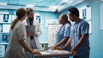 Neuroscience expert reviewing mri brain scan results with doctors, discussing the right treatment plan for disease prevention. Licensed neurologist and his staff examine tomography. Camera B. video
