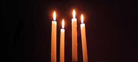 A beautiful scene where four candles are lit in a row. photo