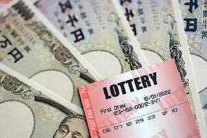 Lottery tickets lies with japanese yen bills on gambling sheets with numbers for marking to play lottery photo
