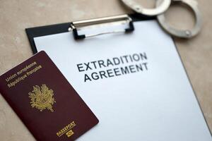 Passport of France and Extradition Agreement with handcuffs on table photo
