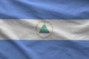 Nicaragua flag depicted on folded wavy fabric of old cloth photo
