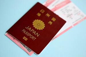 Japan passport with airline tickets on blue background close up photo