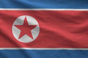 North Korea flag depicted on folded wavy fabric of old cloth photo