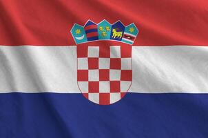 Croatia flag depicted on folded wavy fabric of old cloth photo
