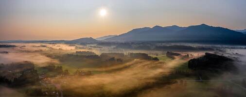 Sunset Panorama with drone at the Bavarian Alps. Mist and fog at the ground photo