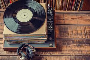 A record player and headphones on a wooden table photo