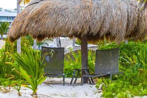 Palm tree Palapa roof tables hats on the beach Mexico. photo