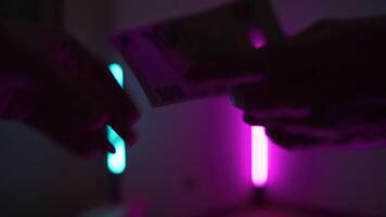 Hand Exchanging Money Checking If They Are Real At UV Scanner video