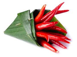 Red chili peppers Wrapped in banana leaves isolated on a white background photo