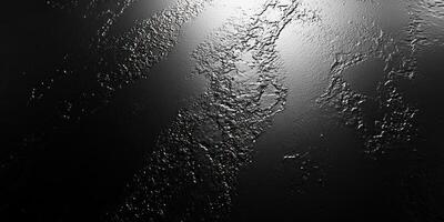 A Textured Black Surface with Light Reflecting on it photo