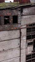Abandoned building during war time. Destroyed building with broken windows. Exterior of ruined architecture. Vertical video