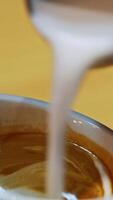 Barista making of cafe latte art. Heart shape on coffee in a cup. Making latte by pouring milk slowly into a blue cup. Close-up. Vertical video