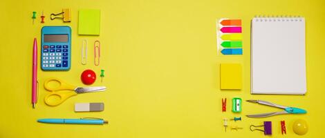 Notebook on a spring for notes and stationery lie on a yellow background photo