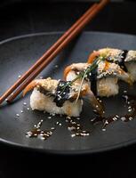 Sushi with smoked eel. Unagi nigiri and chuka salad with sauce a photo