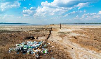 Heaps of garbage on the bank of the Kuyalnik estuary, ecological problem of environmental pollution, south of Ukraine photo