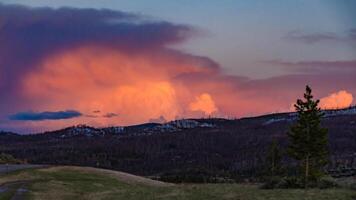 A beautiful red sunset over the mountains overgrown with coniferous forest. US photo