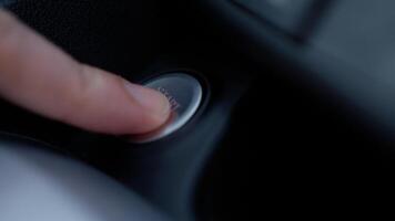 Finger pressing engine start button on car The driver pushing on automatic start stop button. photo